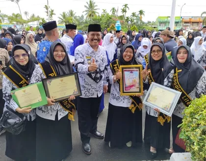 Dr. Sofiawati bersama rekan guru dan pejabat daerah, memamerkan piagam penghargaan